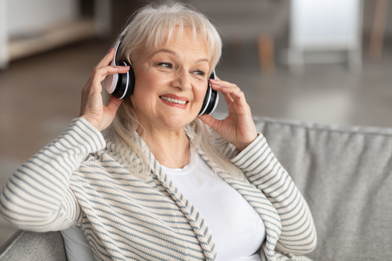 Satisfied smiling mature woman listening to music